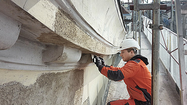 Foto ein Bauarbeiter beim Bearbeiten einer Fassade