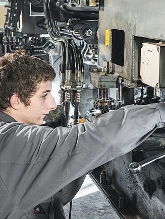 Foto Auszubildender beim Bedienen einer Maschine